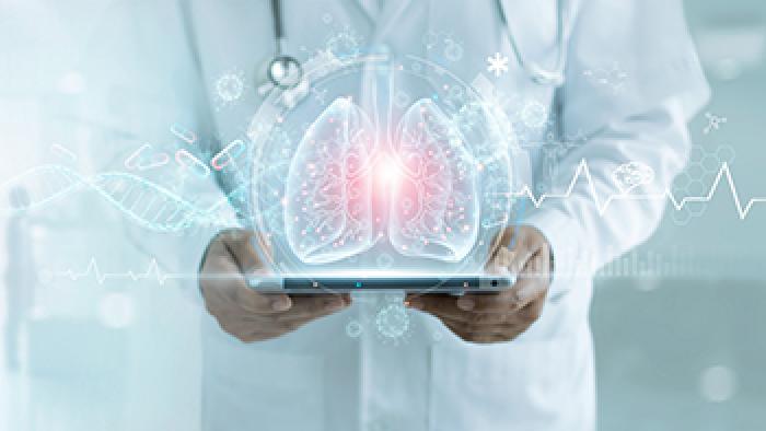 Ein Arzt hält ein Tablet. Über dem Tablet schwebt eine holographische Darstellung einer Lunge.